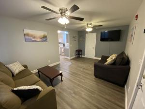 a living room with two couches and a ceiling fan at 1 Bed 1 Bath Suite On Strip in Geneva