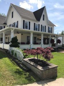 a large white house with a tree in a flower pot at 1 Bed 1 Bath Suite On Strip in Geneva