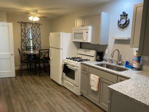 a kitchen with white appliances and a dining room table at 1 Bed 1 Bath Suite On Strip in Geneva