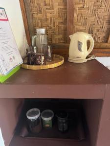 a shelf with a pot and other items on it at Rising Sun Bungalows in Gili Meno