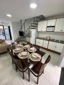 a dining room with a table and chairs and a staircase at Casa nova e ampla, completa para sua hospedagem in Joinville