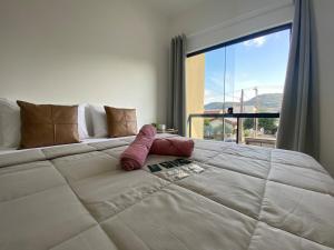 a large white bed in a room with a large window at Casa nova e ampla, completa para sua hospedagem in Joinville
