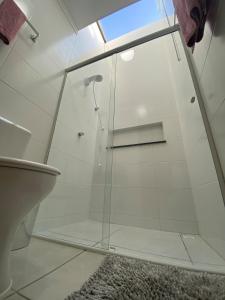 a glass shower in a bathroom with a rug at Casa nova e ampla, completa para sua hospedagem in Joinville +47 photos
