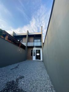 a house with a walkway in front of a building at Casa nova e ampla, completa para sua hospedagem in Joinville