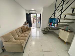 a living room with a couch and a tv at Casa nova e ampla, completa para sua hospedagem in Joinville