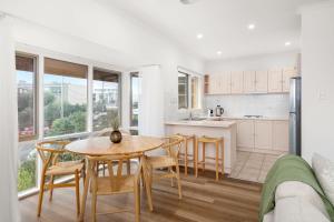 a kitchen and dining room with a table and chairs at Sunset Drift Edithvale Steps to Beach in Edithvale