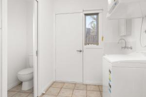 a white bathroom with a toilet and a sink at Sunset Drift Edithvale Steps to Beach in Edithvale +4 photos