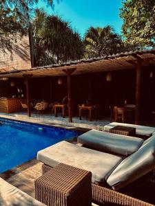 a swimming pool with chaise lounges and chairs next to a resort at Home Dejavu in Gili Trawangan