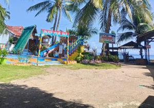 a park with a playground with a slide and palm trees at Mannor Beach Resort by Hiverooms in Carmen