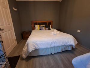 a bedroom with a large bed with white sheets at El Laurel in Chillán