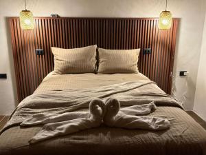 a bed with a heart shaped towel on it at INTUS Lodge Rio Celeste in El pilon