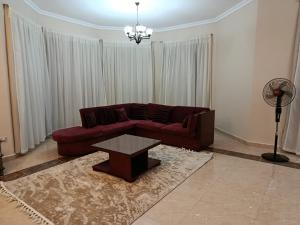 a living room with a red couch and a table at Stand alone Villa at Blumar North coast -SIDI ABD ALRAHMAN in El Alamein