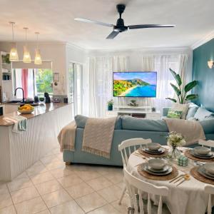 a living room with a blue couch and a kitchen at Luxury 2 Bedroom apartment, Treetop views, Resort with 4 swimming pools in Cairns North