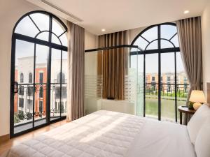 ein Schlafzimmer mit einem großen Bett und großen Fenstern in der Unterkunft Sun Hotel Sam Son in Sầm Sơn + 32 Fotos