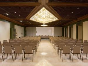 a large room with rows of chairs and a large window at Mövenpick Hotel Bari in Bari
