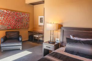 a bedroom with a bed and a chair and a desk at Red Tree Oaxaca in Oaxaca City