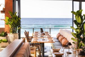 a long dining room with a view of the ocean at Peppers Soul Surfers Paradise in Gold Coast
