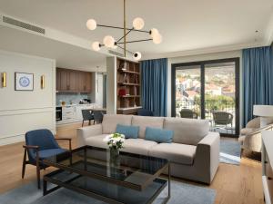 a living room with a couch and a table at Mövenpick Hotel & Residences Teuta Kotor Bay in Kotor
