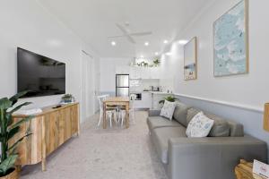 a living room with a couch and a kitchen at ABSOLUTE BEACH FRONT MACKAY - Blue Pacific in Mackay