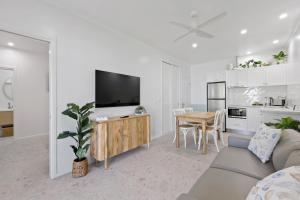 a living room with a couch and a tv and a table at ABSOLUTE BEACH FRONT MACKAY - Blue Pacific in Mackay +85 photos