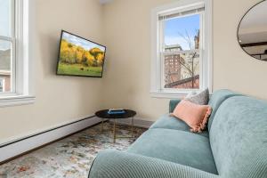 a living room with a blue couch and two windows at King Bed Sleeps 3 2 Beds Walkable Cozy in Philadelphia