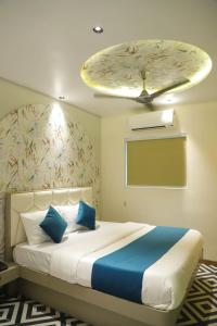 a bedroom with a large bed with a ceiling at Ashray Guest House in Kalyan