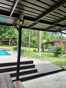 a wooden pergola with stairs next to a pool at La macana Ecotour in Cacique