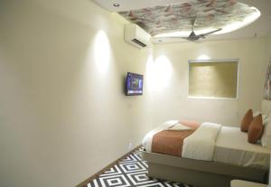 a bedroom with a bed and a ceiling at Ashray Guest House in Kalyan +4 photos