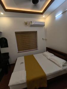 a small bedroom with a bed with a window at Ram's Heaven in Guruvāyūr