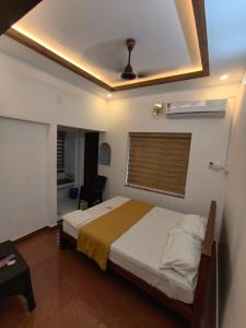 a bedroom with a large bed and a window at Ram's Heaven in Guruvāyūr