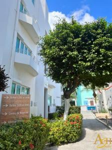 a building with a tree and a sign in front of it at Angeles Suites & Hotel in Veracruz