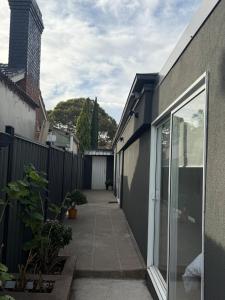 a walkway between two buildings with a fence at The Hideaway in Sydenham