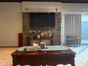 a living room with a flat screen tv on a stone wall at The Hideaway in Sydenham +3 photos