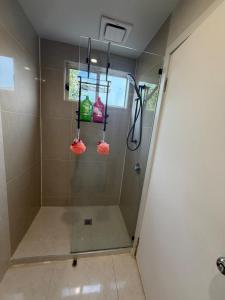 a bathroom with a shower with two bags on it at The Hideaway in Sydenham