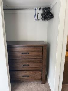 a closet with a wooden dresser in a room at The Hideaway in Sydenham