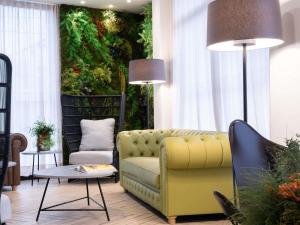 a living room with a yellow couch and a table at ibis Styles Santander in Santander