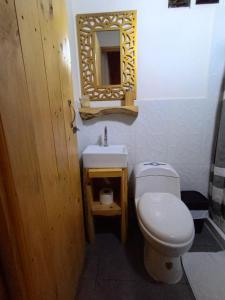a bathroom with a toilet and a sink and a mirror at Sigchos Lodge in Sigchos +26 photos