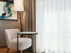 a table and a chair next to a window at Mercure Dubai Gold District in Dubai