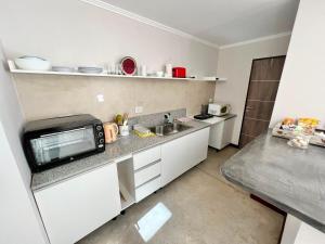 a kitchen with a counter top with a microwave at Departamento PIPE in Bella Vista +5 photos