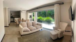 a living room with a couch and chairs and a large window at Departamento PIPE in Bella Vista