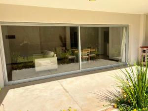 a large glass window of a house with a patio at Departamento PIPE in Bella Vista
