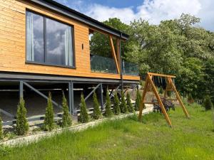 a house with a swing in front of it at Royal Hill-Prince Chalet Bran- Mountain View and Hot Tub in Sohodol