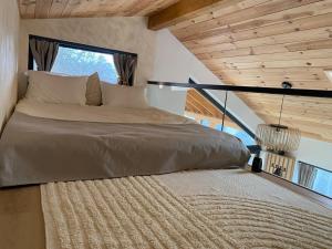 a large bed in a room with a window at Royal Hill-Prince Chalet Bran- Mountain View and Hot Tub in Sohodol
