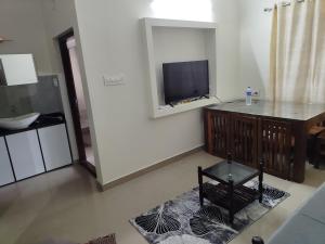 a living room with a flat screen tv on a wall at Ocean wings Traditional beach villa in Kaipamangalam