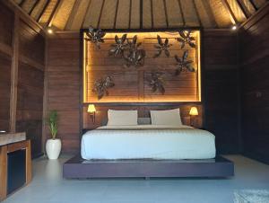 a bedroom with a bed with a wooden wall at Sri Abi Ratu Villa in Sukawati +27 photos