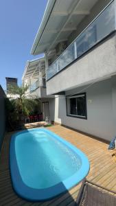 a large blue swimming pool in front of a house at Sobrado 4 suítes, piscina , para até 12 pessoas 650 metros da praia de Bombinhas in Bombinhas