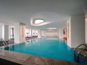 a large pool with blue water in a building at Pullman Chongqing Xiyue in Chongqing
