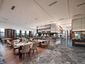 a restaurant with tables and chairs and a buffet at Pullman Chongqing Xiyue in Chongqing