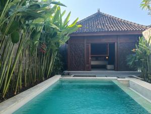 a swimming pool in front of a villa at Sri Abi Ratu Villa in Sukawati