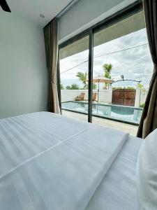 a bedroom with a bed and a view of a pool at LAA Maison in Hoi An +133 photos